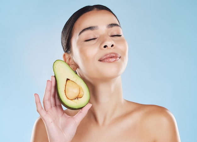 Avocado skincare woman beauty and natural cosmetic wellness for healthy diet feminine results and clean glowing skin on blue background Bodycare nutrition and young model face grooming and fresh