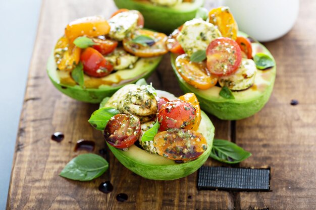 Photo avocado stuffed with pesto caprese salad