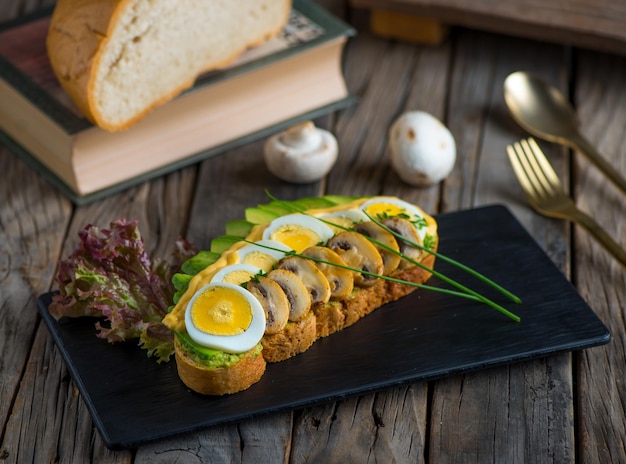 Avocado toast with mushroom and egg isolated on cutting board side view of breakfast