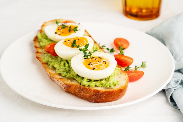 Avocado toast with toasted bread soft-boiled eggs with tomatoes