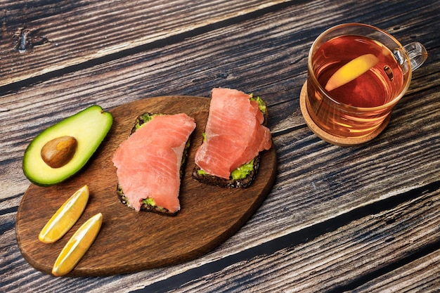 Avocado toast with whole wheat bread guacamole and smoked salmon on cutting board