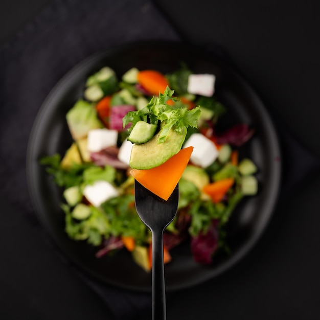 Avocado and vegetable salad Salad on a fork macro