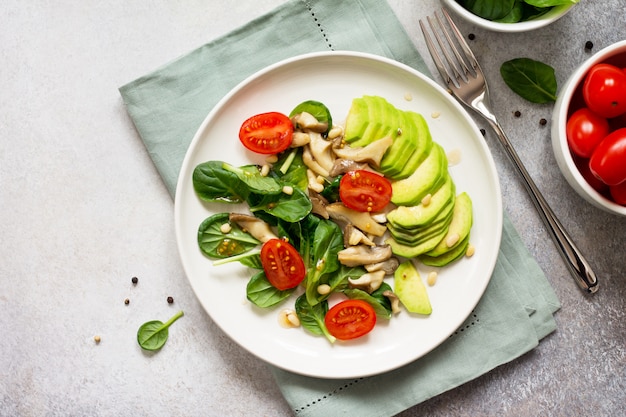 Avocado with tomatoes and spinach on a plate