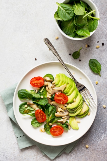 Avocado with tomatoes and spinach on a plate