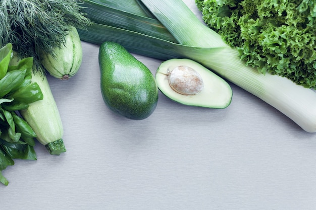 Avocado, zucchini and greens as a background