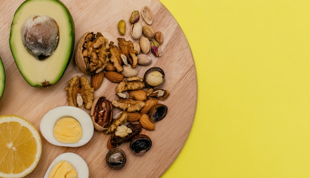 Аvocadoeggslemonnuts on the wooden cutting board