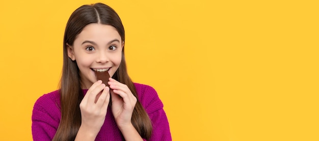 Photo award yourself with one bite happy girl eat chocolate chocolate eating enjoying sweet snack horizontal poster of isolated child face banner header copy space