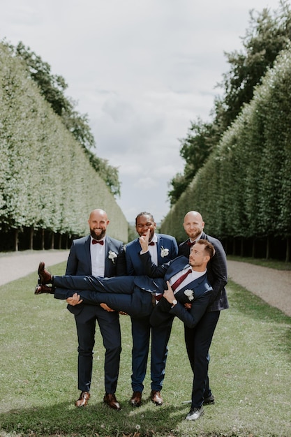 Awesome groom and groomsmen getting crazy in the forest and performing tricks on a wedding day.