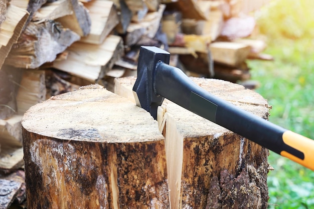 Axe in crack of firewood for separation of parts close-up