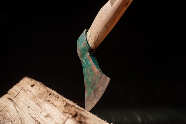 Axe and log on dark background Firewood harvesting for winter concept