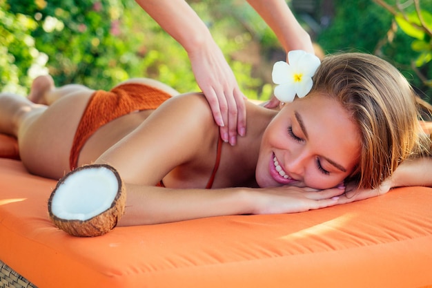 Ayurvedic relaxing massage health beauty happy closed eyes woman in spa salon getting massage on the holiday beachBeautiful girl enjoying day spa resort lying down on the table treatment procedure