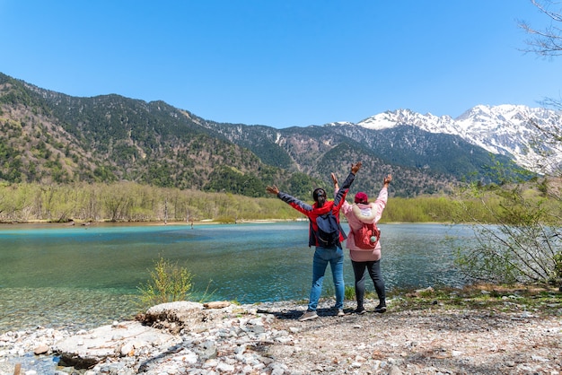 Azusa turquoise color river at Kamikochi in Northern Japan Alps with female hiker.