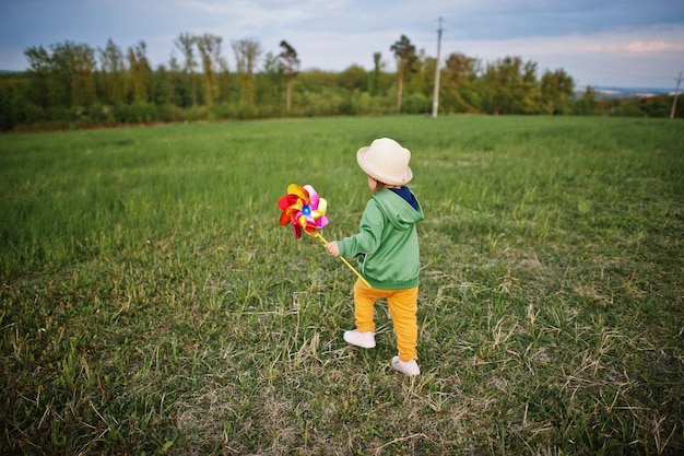 Babay girl with pinwheel at meadow