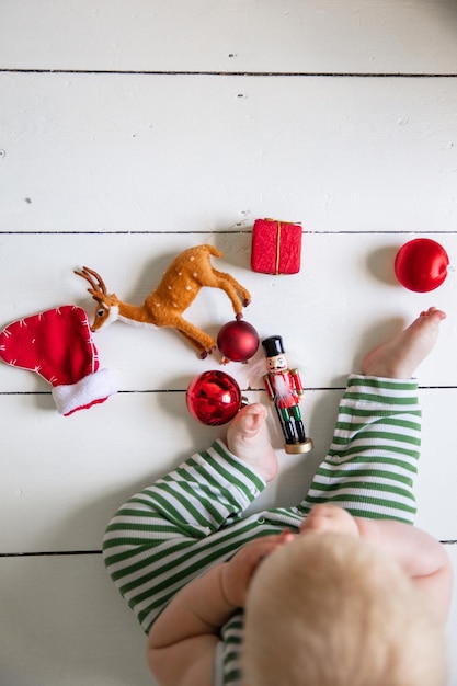 Photo babies first christmas celebration playing with festive toys on a wooden floor