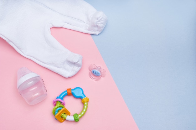 Baby accessories on pink and blue background. Flat lay . Top view Copy space.