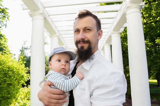 Baby in the arms of dad on a sunny day on a light background