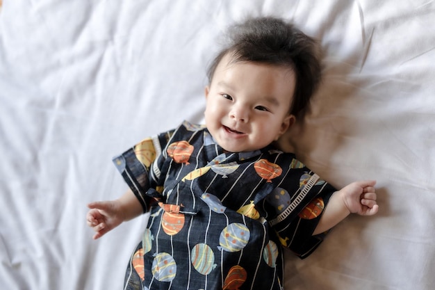 A baby in a black kimono with the words " momo " on the front.