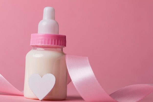 Baby bottle on a pastel pink background New baby arrival