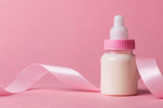 Baby bottle on a pastel pink background New baby arrival