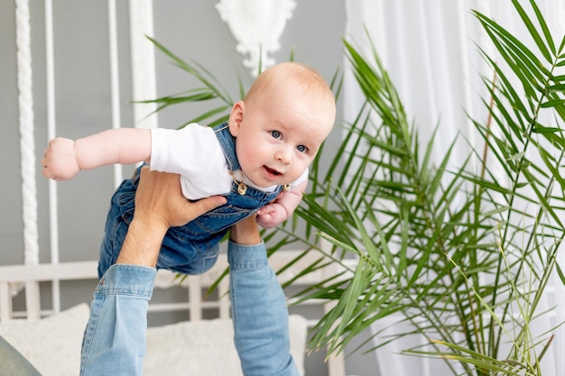 Baby boy in dad's arms playing airplane happy childhood