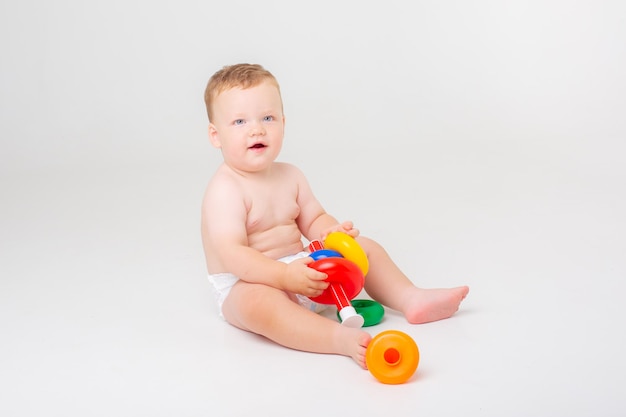 Baby boy in a diaper playing pyramid on a white background studio