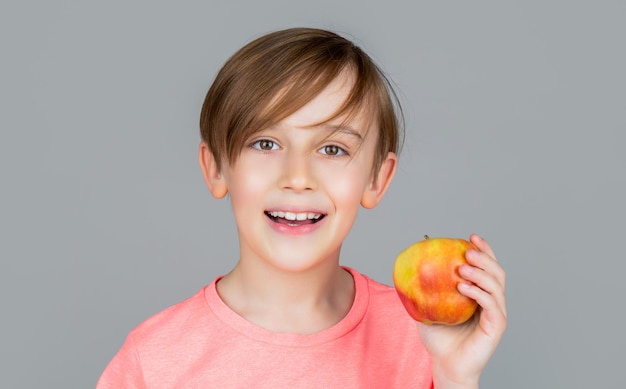 Baby boy eating apple and smiling Boy smiles and has healthy white teeth Little boy eating apple Boy apples showing Child with apples Portrait of cute little kid holding an apple