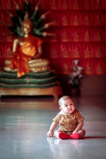 A baby boy is happily playing at a Thai temple.