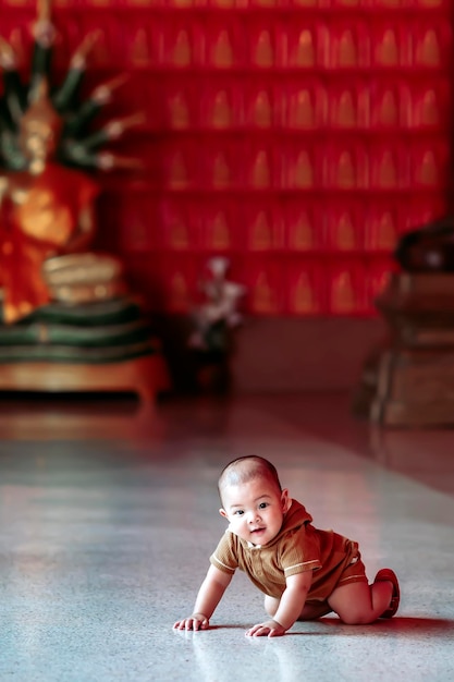 A baby boy is happily playing at a Thai temple.