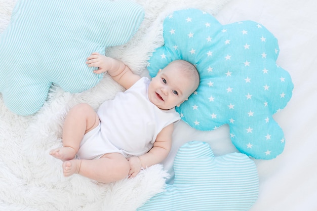 Baby boy lying in bed before going to bed cute laughing sixmonthold smiling little baby