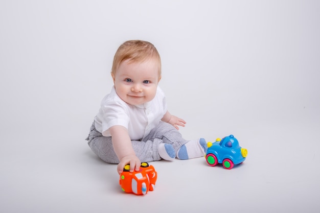 baby  boy playing with toy cars on white background