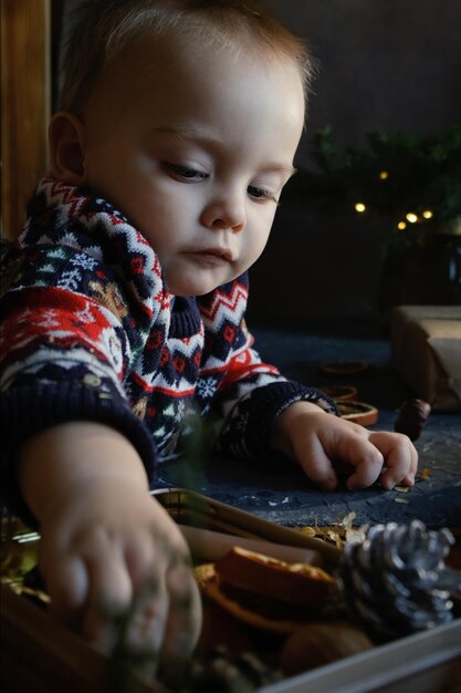 Baby boy touching Christmas bauble at home