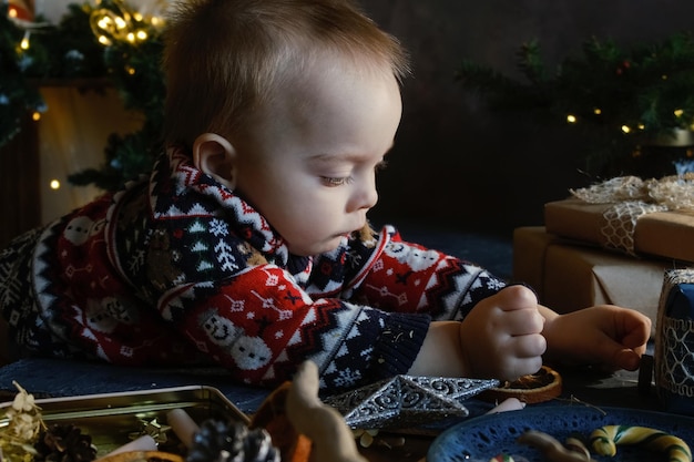 Baby boy with Christmas bauble at home