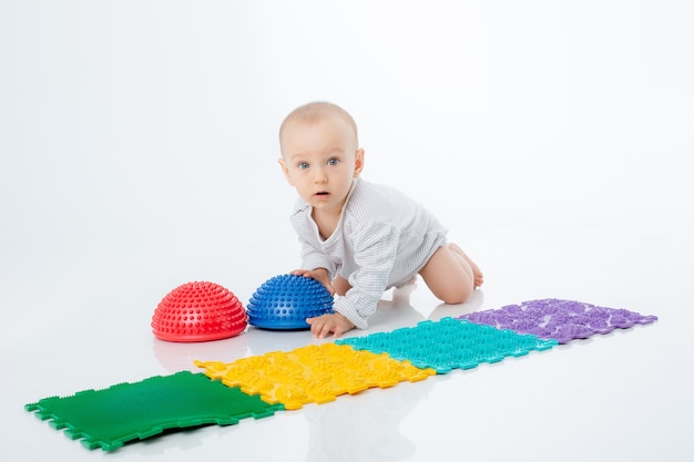 A baby boy with an orthopedic mat and a hemisphere is isolated on a white background