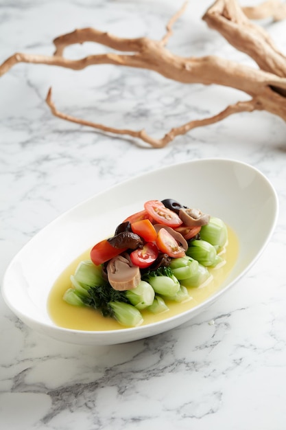 Baby Cabbage with Fungus in Superior Soup served in a dish isolated on grey background