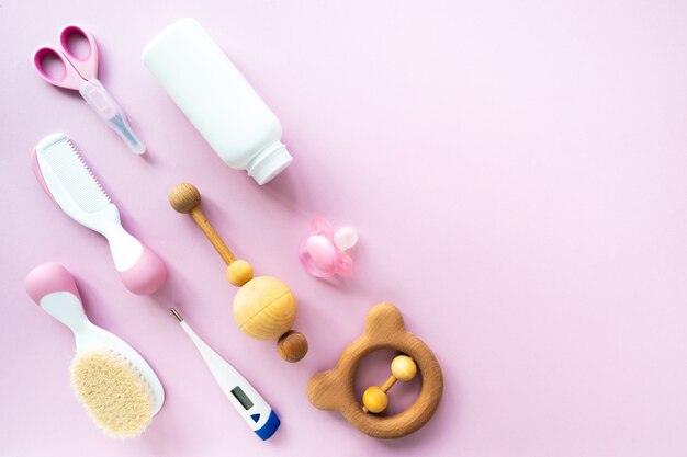 Baby care kit on pink background, top view, copyspace. Concept of children's hygiene. Flat composition with children's accessories, background..