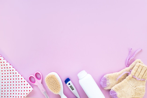 Baby care kit on pink background, top view, copyspace