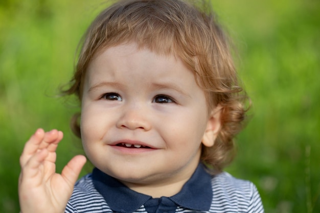 Baby child boy enjoy the summer on the nature in the park outdoor baby face close up funny little ch