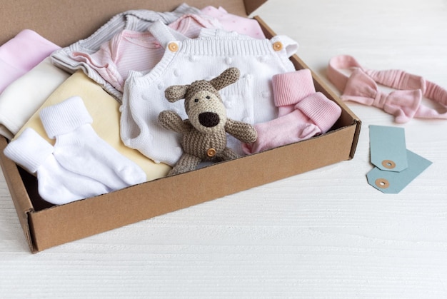 Photo baby and child clothes and knitted toys in carton box