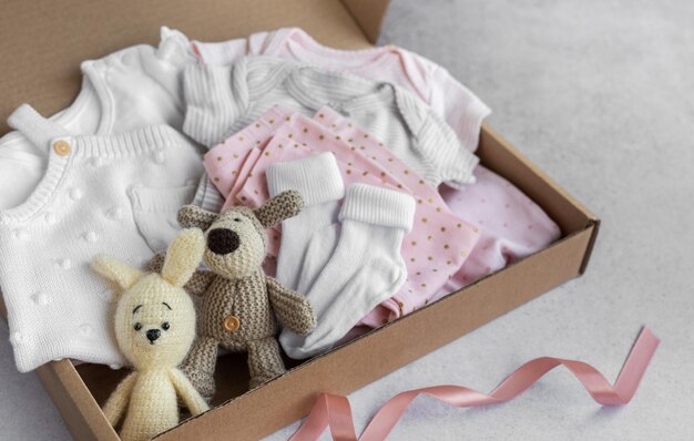 Baby and child clothes and knitted toys in carton box