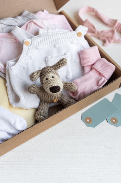 Photo baby and child clothes and knitted toys in carton box