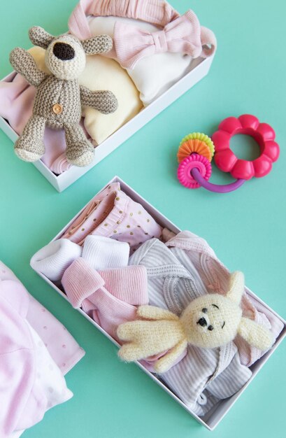 Baby and child clothes and knitted toys in carton box