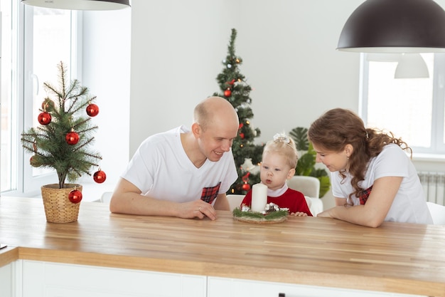 Baby child with hearing aid and cochlear implant having fun with parents in christmas room Deaf diversity and health concept