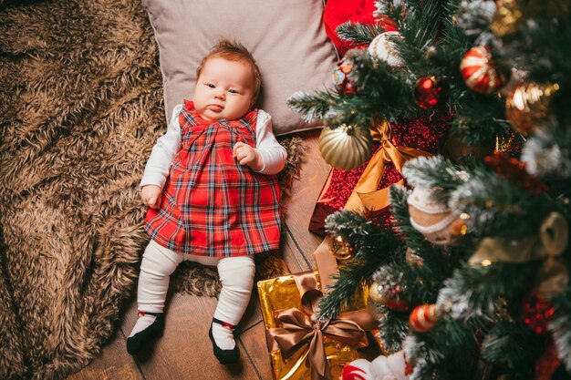 Baby next to the Christmas tree