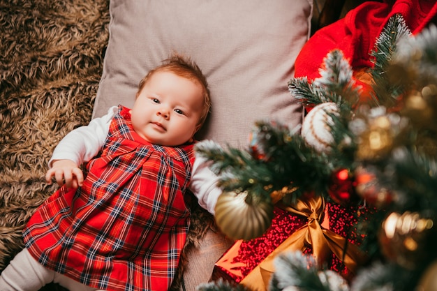 Baby next to the Christmas tree