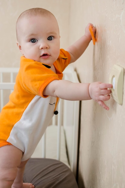 Baby climbing on a wall with a switch