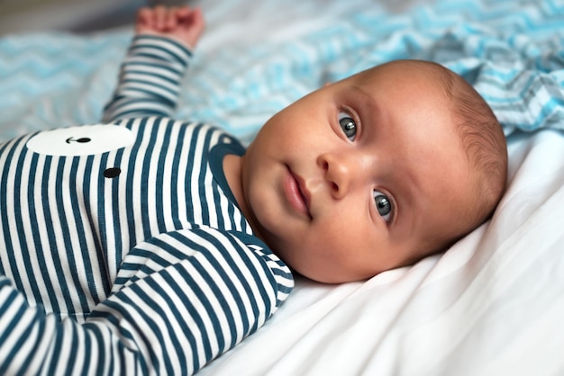 Baby in clothes lying on the bed Portrait close-up of a cute baby