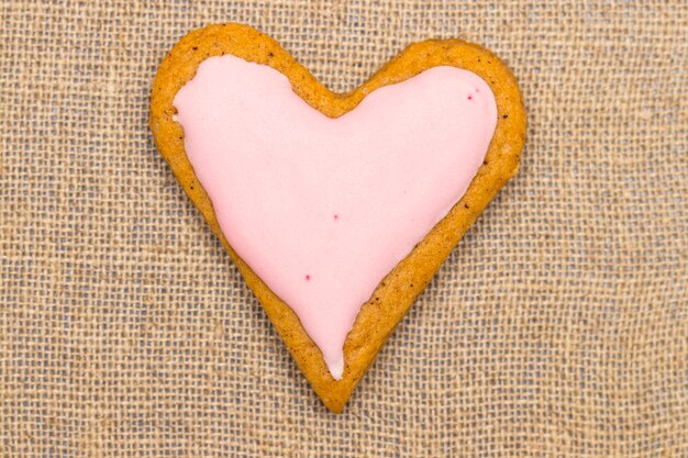 Baby cookie on burlap in a heart shape.