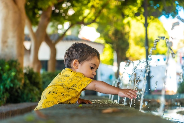 A baby cooling off from the heat in the fountain in the municipality of Mijas in Malaga Andalusia