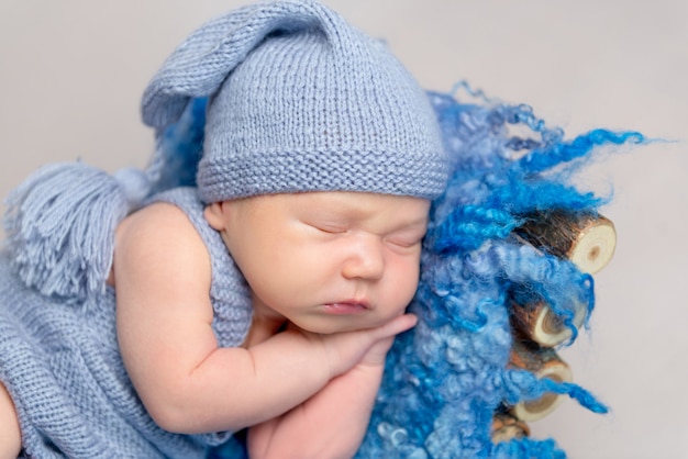 Baby dressed in knitted yellow costume sleeping on crib