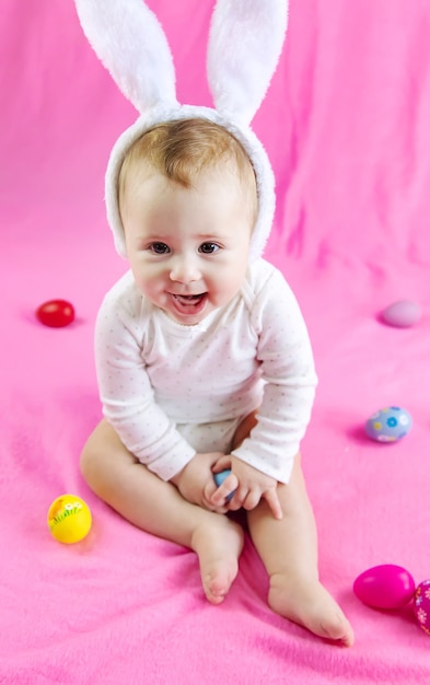 Baby dressed like a bunny with Easter eggs for Easter holiday